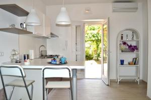 a kitchen with a white counter and chairs in it at Porticciolo in San Vito