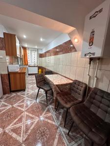 a room with a table and chairs and a kitchen at Apartament Băile Herculane in Băile Herculane