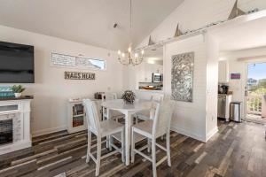 Una cocina y un comedor con una mesa y sillas blancas. en Freestyle Surf-Inn, en Nags Head