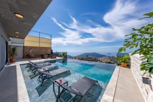 a swimming pool with tables and chairs on a building at Villa Kayras 3 in Kas