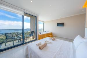 a bedroom with a white bed and a large window at Villa Kayras 3 in Kas