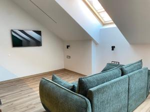 a living room with two blue couches and a skylight at Luxury Old Town River Apartment in Klaipėda