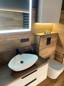 a bathroom with a white sink and a toilet at Luxury Old Town River Apartment in Klaipėda