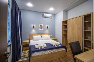 a bedroom with a bed with two towels at Green Garden Guesthouse in Tbilisi City