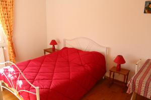 ein rotes Bett in einem Zimmer mit zwei roten Lampen in der Unterkunft Ferme Pédagogique " L'Bout d'Chemin" in Genevreuille