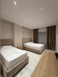 two beds in a hotel room with two bedsvisor at Azure Waves in Vlorë