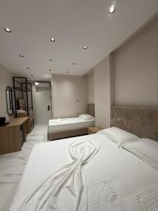 a bedroom with two beds with white sheets at Azure Waves in Vlorë