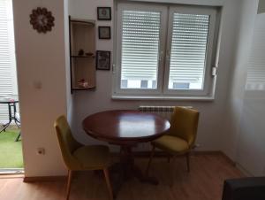 a dining room with a wooden table and two chairs at Nela studio in Banja Koviljača