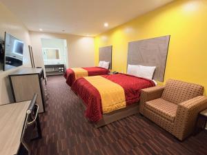 ein Hotelzimmer mit zwei Betten und einem Stuhl in der Unterkunft Americas Best Value Inn Houston Veterans Memorial in Houston