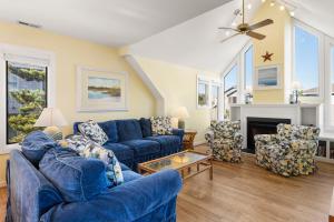 a living room with blue couches and a fireplace at Fun2Sea in Corolla