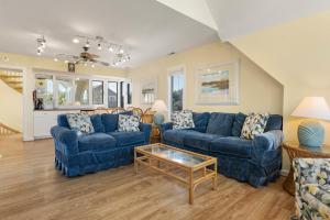 a living room with two blue couches and a table at Fun2Sea in Corolla