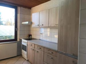 a kitchen with white cabinets and a window at PensionLien in Köthen