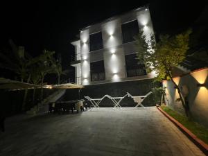 a building with lights on the side of it at night at Azure Waves in Vlorë