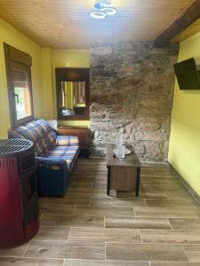 a living room with a couch and a stone wall at Casa Divina in Lago de Carucedo