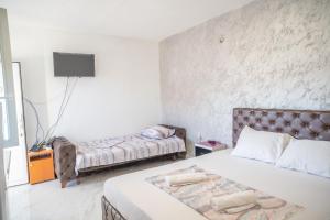 a bedroom with two beds and a tv on the wall at Apartmani Medovic in Ulcinj