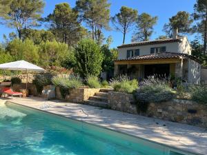 a house with a swimming pool in front of a house at Piscine chauffée, tennis, Mas provençal contemporain in Draguignan