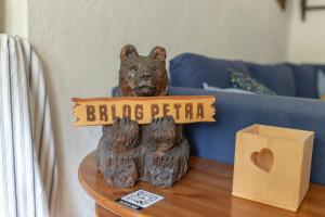 克拉尼斯卡戈拉Apartma Brlog Petra, Kranjska Gora的桌子上放着一个木熊雕像，旁边还有一个盒子 更多14张照片