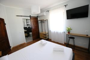 a room with a white table and a tv at Areté rooms in Cupra Marittima
