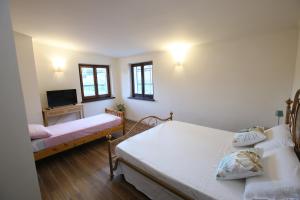 a bedroom with two beds and a flat screen tv at Areté rooms in Cupra Marittima
