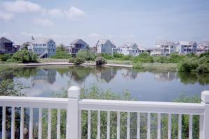 a white fence and a lake with houses at Gone Fishin in Nags Head