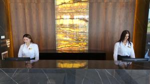 Duas mulheres sentadas numa mesa no átrio. em PALEMON Resort& Spa em Manavgat