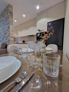 a table with glasses and utensils on top of it at Apartament on StyleUp StayRent Lutsk in Lutsk