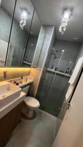 a bathroom with a shower and a toilet and a sink at Quarto para mulheres em Cond Orla Recreio Prainha in Rio de Janeiro
