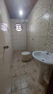 une salle de bain avec un lavabo et des toilettes dans l'établissement casa do fred enseada, à Guarujá