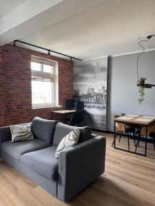 a living room with a couch and a brick wall at Modern, stylish apartment in the heart of the city in Szczecin