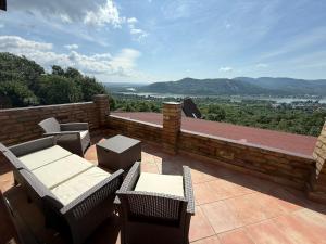 大毛罗什Forestin Vendégház的阳台上摆放着桌椅的露台