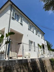a white house with chairs on a balcony at Villa Viola Rooms, a 200mt dalla spiaggia di Procchio in Procchio