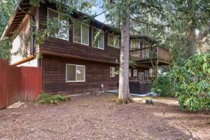 ein Holzhaus mit einem Baum davor in der Unterkunft Pet Friendly Retreat Hot Tub & Games On Mt Hood in Mount Hood Village