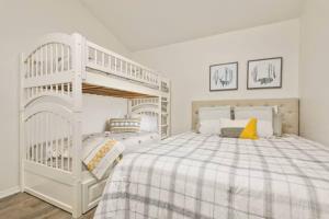 ein weißes Etagenbett in einem weißen Zimmer mit einem Bett in der Unterkunft Pet Friendly Retreat Hot Tub & Games On Mt Hood in Mount Hood Village + 34 Fotos