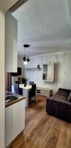 Una cocina y una sala de estar con una mesa y un sofá. en Must Apartaments, en Polignano a Mare