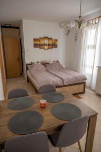 a bedroom with a bed and a table and chairs at Szent Anna Vendégház in Bükkszék +7 photos