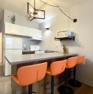 een keuken met een aanrecht en oranje stoelen bij Refuge Urbain Quebec - Lofts de la Cité in Québec