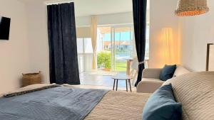 a bedroom with a bed and a couch and a window at Sunny Sea Garden Apartment in Mijas Costa