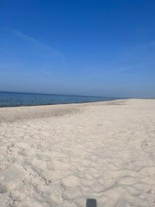 a shadow of a person standing on a beach at Willa Anna in Mielno +18 photos