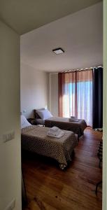 Una habitación de hotel con dos camas y una ventana. en Must Apartaments, en Polignano a Mare