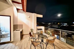 Un comedor con mesa y sillas en un balcón. en Vive a 5min centro 2HAB con A/C Terraza & Parrilla, en Tarapoto