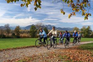 a group of people riding bikes down a gravel road at Ferienwohnung Fritzenwenger in Übersee
