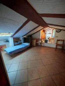 une grande chambre mansardée avec un lit et des chaises dans l'établissement Santa Teresa mansarda parking centro, à Santa Teresa Gallura 35 autres photos