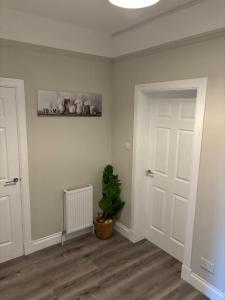 a room with a door and a plant in it at 2 bedroom first floor flat- Bonnie Stays in Troon