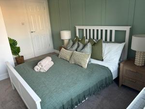 a bed with pillows and towels on it in a bedroom at 2 bedroom first floor flat- Bonnie Stays in Troon