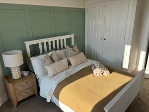 a bedroom with a large bed with pillows on it at 2 bedroom first floor flat- Bonnie Stays in Troon