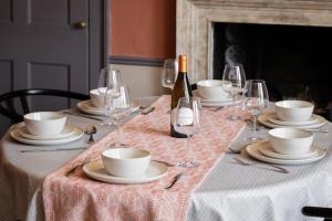 a table with plates and glasses and a bottle of wine at Walcot Townhouse 3 bedroom in Bath