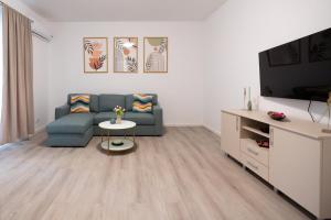 a living room with a couch and a table at Soni Exclusive Apartments 1218 Plaza with Private Parking & Self Check-in in Bucharest