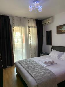 a bedroom with a bed with two towels on it at Apartman Budva Centar in Budva