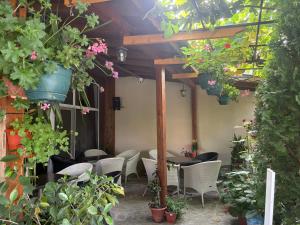 a patio with a table and chairs and potted plants at Rooms Zora in Primorsko