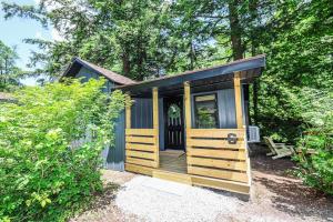 a small shed with a porch and a bench at BrookHaus - Modern Cabin Stay at Harvard Brook in Lincoln